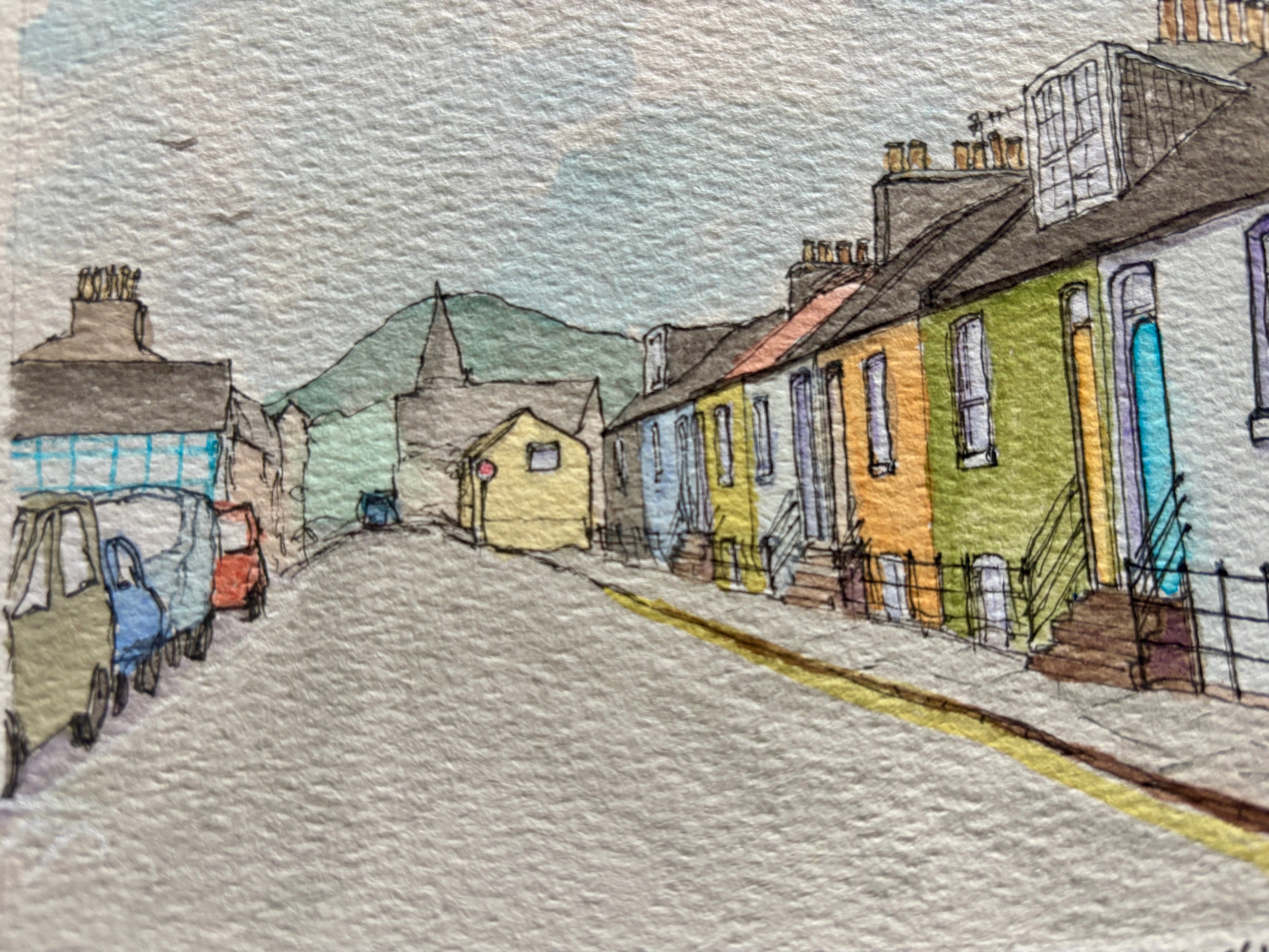 Colorful row of houses on a street with mountains in the background